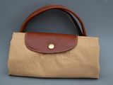 sac en toile beige et marron avec une poignée en cuir