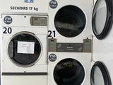 a row of washers and dryers in a public washroom