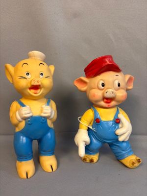 deux figurines représentant un cochon et un cochon en salopette bleue