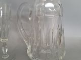 two glasses and a pitcher sitting on a table