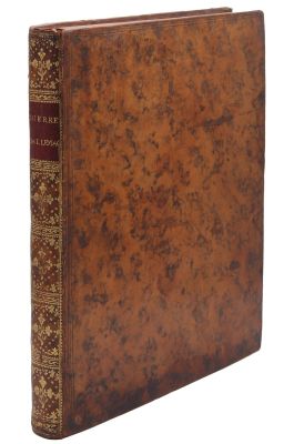 un vieux livre à la couverture brune posé sur une surface blanche