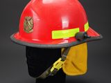 a red fireman ' s hat with a yellow hat on it