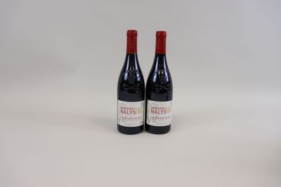 deux bouteilles de vin rouge posées l'une à côté de l'autre sur une surface blanche