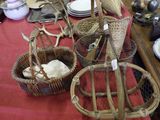 a table with baskets and plates on it with a red table cloth