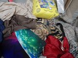 a pile of clothes and a pillow on the floor