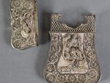two silver metal items on a gray surface with a gray background