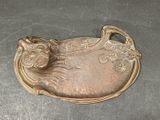 a metal tray with a cat on it on a table