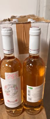 trois bouteilles de vin posées sur une table, à côté d'un carton