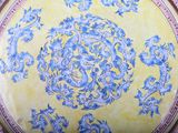a blue and yellow plate with a dragon design on it