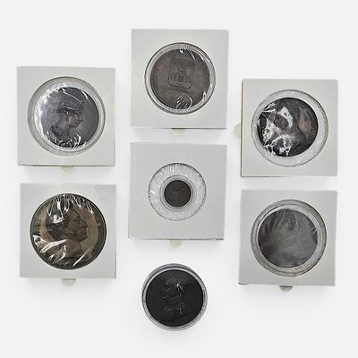 six types de pièces différents dans une boîte blanche posée sur une surface blanche