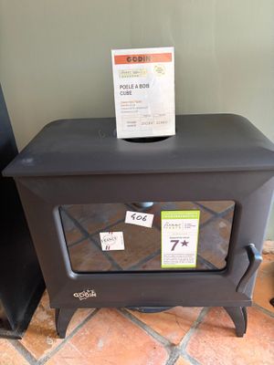 a small black stove with a sign on top of it