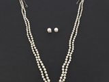 un ensemble composé d'un collier et de boucles d'oreilles en perles blanches