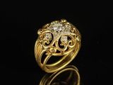a gold ring with diamonds on a black surface