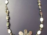 un gros plan d'un collier orné d'une fleur