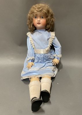 an old doll sitting on a grey surface with a gray background