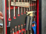 a man holding a tool box with a bunch of tools in it