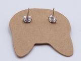 a pair of silver earrings sitting on top of a piece of cardboard