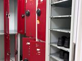 many red lockers in a room with a lot of shoes