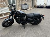a picture of a black motorcycle parked in front of a building