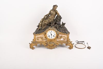une horloge surmontée d'une statue, à côté d'une paire de ciseaux