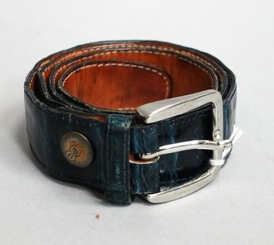 ceinture en cuir bleu avec une boucle argentée sur un fond blanc