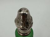 a silver and green bottle with a bird on it