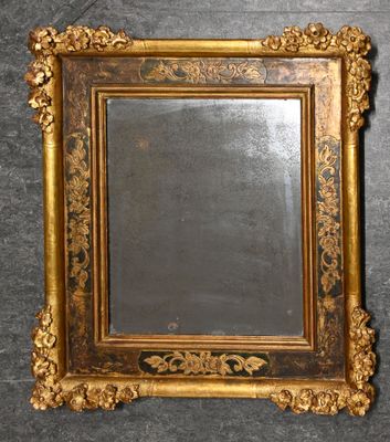 un miroir ancien dans un cadre doré, accroché à un mur sur fond noir