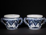 pair of blue and white vases with handles on a black surface