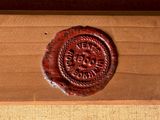 a wax seal that is on top of a wooden box