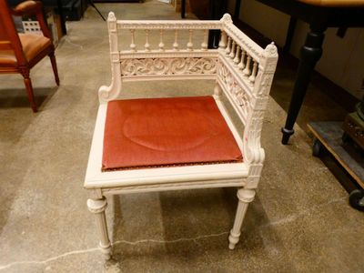 a white bench with a red seat in a room