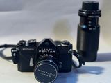 a black camera and a black bottle on a white table