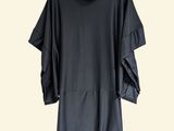the black dress is hanging on a hanger on a white wall
