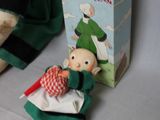 a small stuffed elf sitting next to a box of books