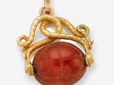 un pendentif en or et en cornaline orné d'un serpent