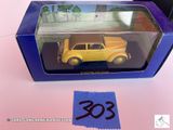 une petite voiture jaune dans une boîte bleue posée sur une table