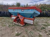 un bateau bleu et rouge posé dans l'herbe
