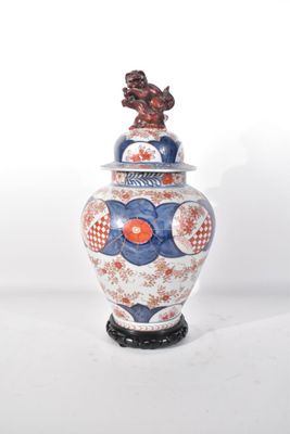 un vase bleu et blanc surmonté d'un oiseau