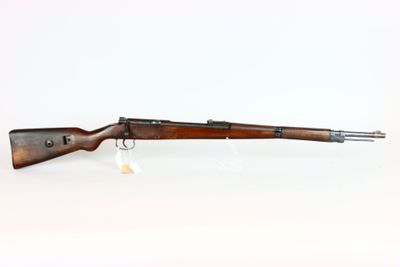 a rifle on a white surface with a white background