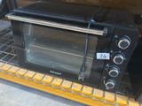un four grille-pain posé sur une étagère en bois