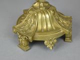 a gold colored candle holder with a bird on top