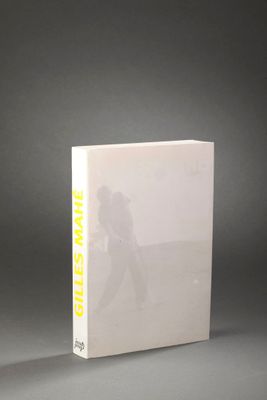un livre blanc avec des lettres jaunes, posé sur une table