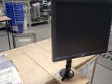 a computer monitor sitting on top of a wooden table