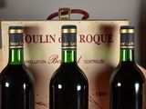 three bottles of wine sitting in a wooden box