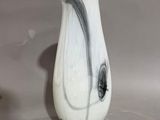 a white vase with a black swirl on it