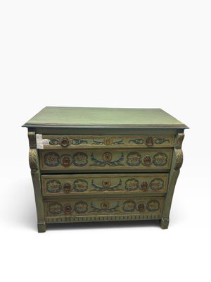 une commode verte dont les tiroirs sont ornés de motifs floraux