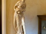 a statue of a woman holding a basket on a pedestal