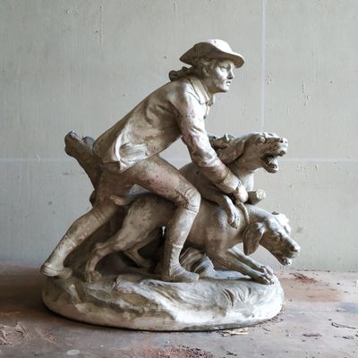 une statue représentant un garçon à cheval accompagné d'un chien