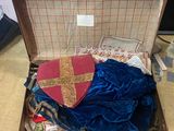 a suit case with a blue cloth and a red cross on it