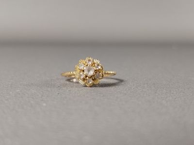 un gros plan d'une bague sertie d'un diamant jaune posée sur une surface grise