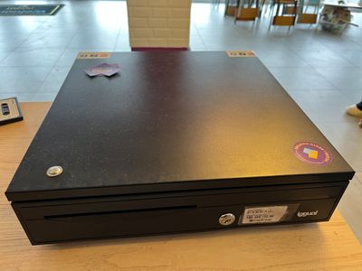une boîte noire recouverte d'autocollants, posée sur une table
